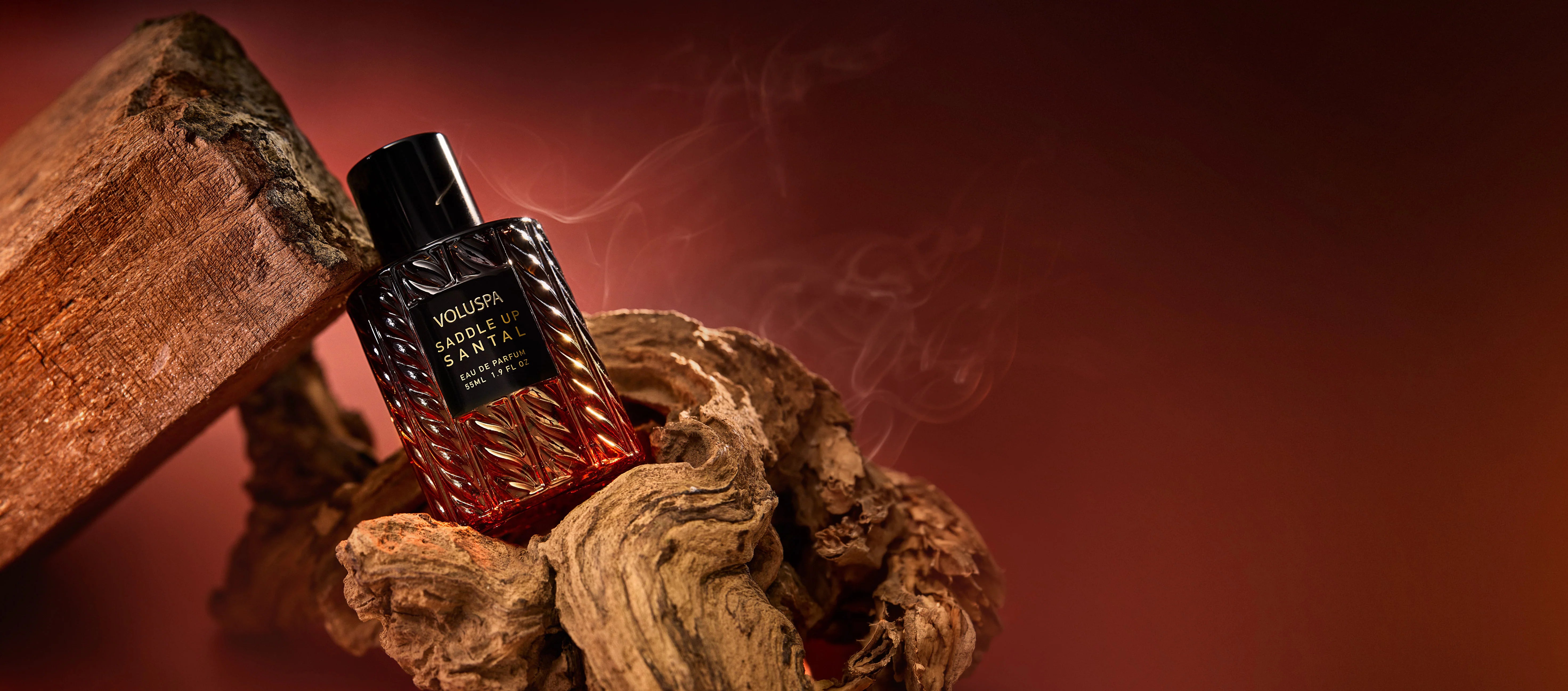 Saddle Up Santal fragrance bottle arranged with warm wood